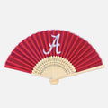 A crimson folding hand fan with a white Alabama Crimson Tide 'A' logo on the upper section, featuring bamboo ribs.